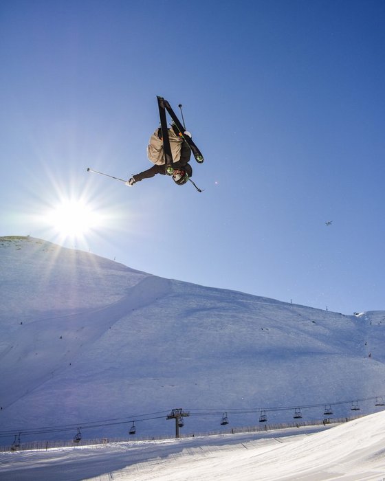Freeskier bei einem Sprung vor blauem Himmel